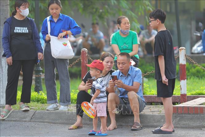 Một gia đình ở lại chờ thí sinh thi môn Toán tại khu vực điểm thi Trường THPT Đan Phượng. Ảnh: Hoàng Hiếu - TTXVN 